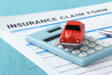 Car insurance concept with calculator and toy carの写真素材