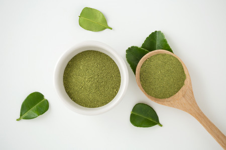 Ground kaffir lime leaves in bowl on white background top viewの写真素材
