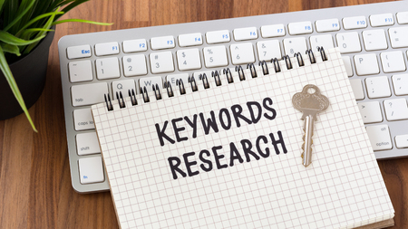 Keywords research words on notebook with key computer keyboardの写真素材