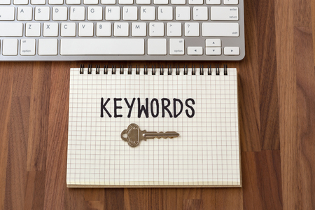 Keywords word with key on notebook with computer keyboardの写真素材