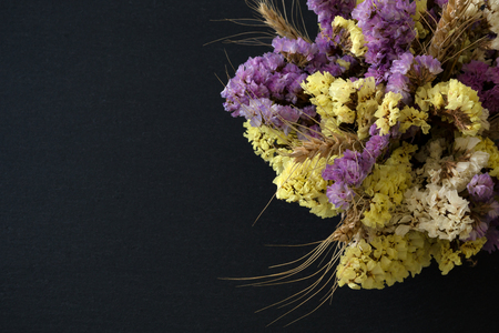 Bouquet of statice flowers on black stone backgroundの写真素材