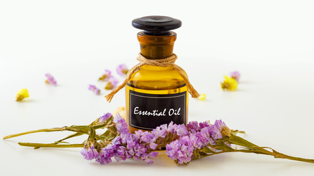 Essential oil with flowers on white backgroundの写真素材