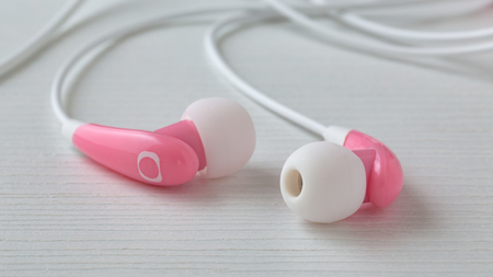 Pink earphones on white wooden tableの写真素材