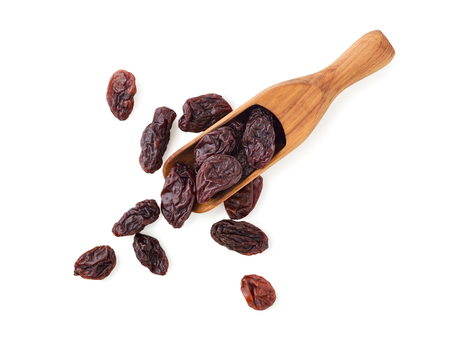 Jumbo raisins in wood scoop isolated on white backgroundの写真素材