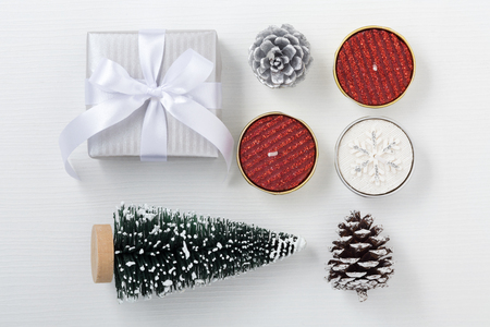 Christmas composition with gift box, candle, pine and christmas tree on white wood tableの写真素材