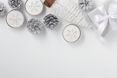 Christmas background with gift box, candle, christmas tree on white wooden table with space, top viewの写真素材