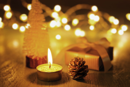 Christmas candle and ornament on dark background with light and bokehの写真素材