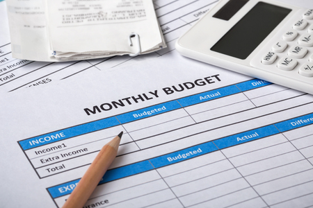 Monthly budget planning concept with calculator, bills and pencilの写真素材