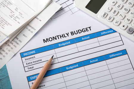 Monthly budget concept with white calculator, bills and pencilの写真素材