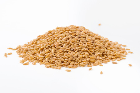 Golden flaxseed isolated on white backgroundの写真素材