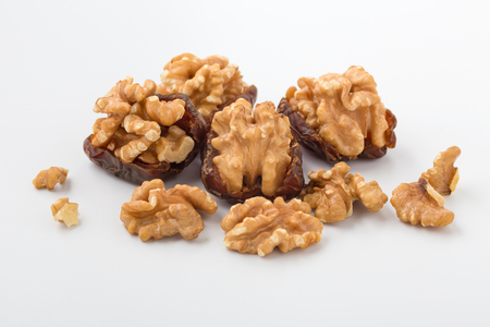 Walnuts in date fruit with walnuts on white backgroundの写真素材