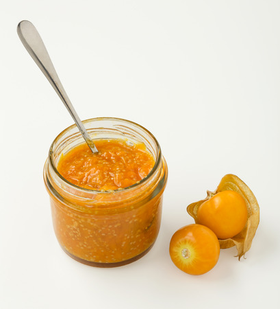 Golden berry or cape gooseberry jam in glass jar isolated on white backgroundの写真素材