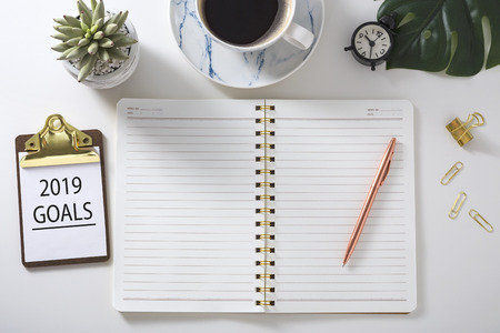 2019 Goal plan with notebook, pen and clipboard on white deskの写真素材