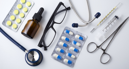 Pills and drug with medical tool on white table backgroundの写真素材