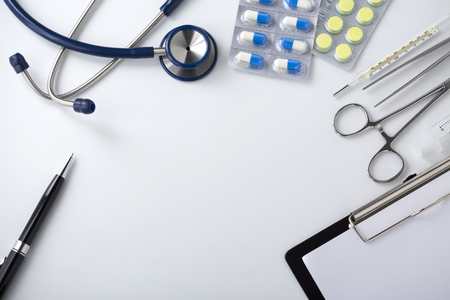 Doctor desk with medical tools and pills, top viewの写真素材