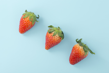 Strawberries on light blue background, flat layの写真素材