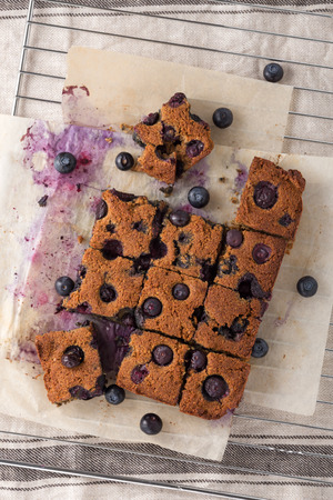 Blueberry square bars on paper baking sheet with blueberries, paleo low carb dessert, top viewの写真素材