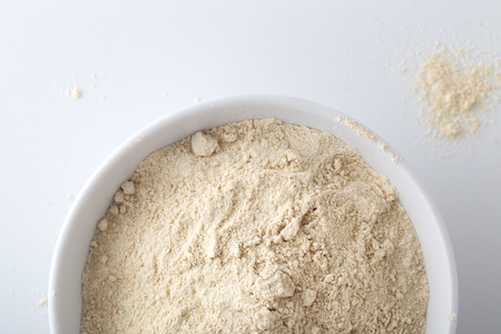 Quinoa flour in white bowl on white background, closeup, top viewの写真素材