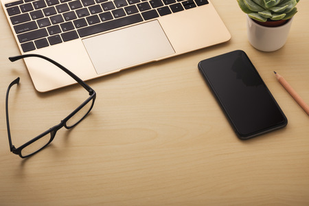 Laptop and smart phone on wooden background with space, digital technology conceptの写真素材