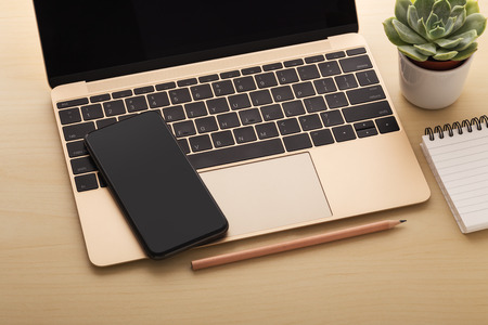 Laptop and smart phone on wooden desk, digital technology conceptの写真素材