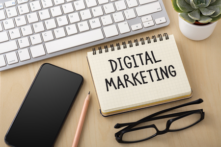 Digital marketing concept with smartphone and computer keyboard on wooden desk deskの写真素材
