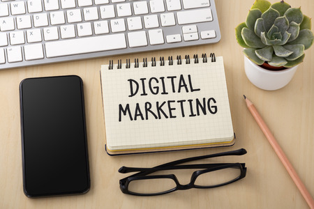 Digital marketing concept with smartphone and computer keyboard on office deskの写真素材