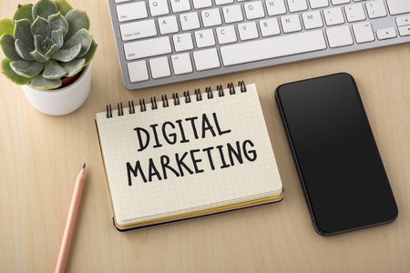 Digital marketing concept with smartphone and computer keyboard on office deskの写真素材