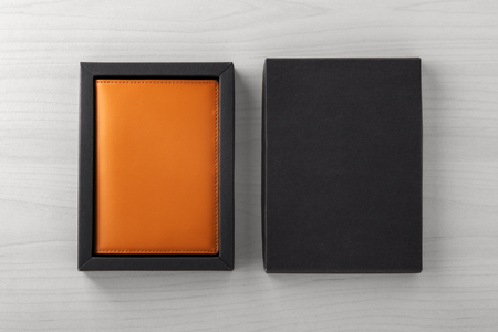 Leather passport case in black box, business gift, on wooden background, top viewの写真素材