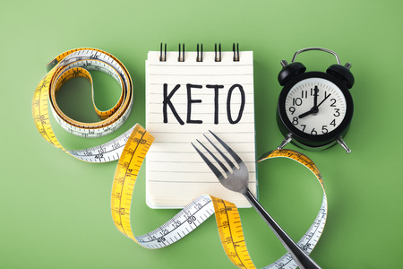 Keto word with clock fork and measuring tape around, intermittent fasting on keto conceptの写真素材