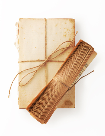Viintage book paper roll on ripped old book with brown string tied on white backgroundの写真素材