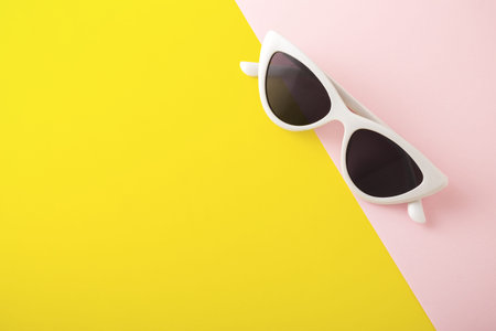 White sunglasses on yellow and pink background