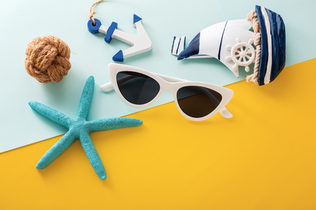 Summer holiday travel concept with white sunglasses and accessories on yellow and blue backgroundの写真素材