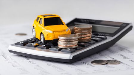 Car and coins on calculator, car loan, buying, leasingの写真素材
