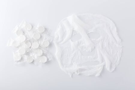 Facial mask and dry sheet mask compressed on white backgroundの写真素材