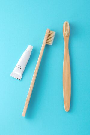 Bamboo toothbrushes with toothpaste, travel size, on blue backgroundの写真素材