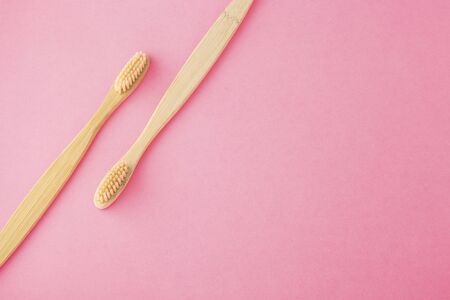 Bamboo toothbrushes on pink background with spaceの写真素材