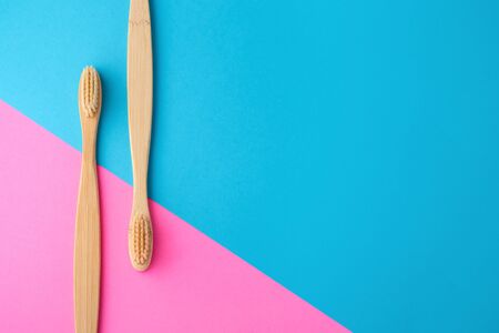 Bamboo toothbrushes on pink and blue background, top viewの写真素材