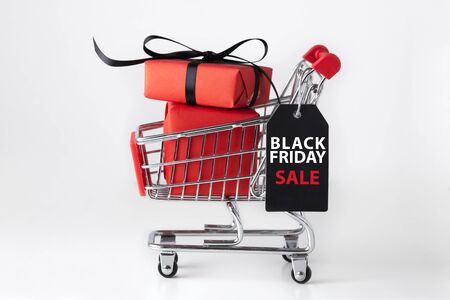 Black friday shopping cart with red box and black bow on white backgroundの写真素材