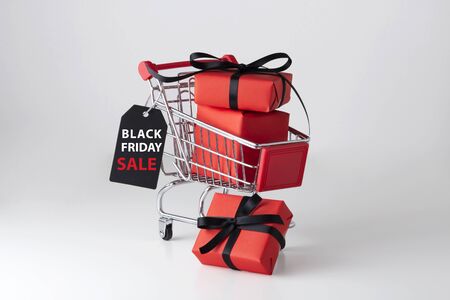 Black friday sale label with red gift box in shopping cartの写真素材
