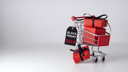 Black friday sale background with red gift box in shopping cartの写真素材