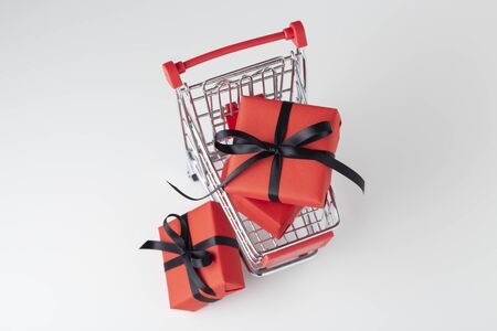 Red gift box with black bow in shopping cart, black friday saleの写真素材