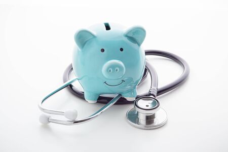 Piggy bank with stethoscope on white background, health insurance conceptの写真素材