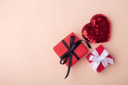 Red gift boxes with glitter heart on pink background with copy space, flat layの写真素材