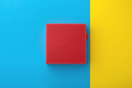 Red wireless speaker on blue and yellow background, flat layの写真素材