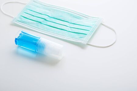 Coronavirus, covid-19 protection mask and alcohol spray on white backgroundの写真素材