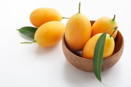 Marian plum, plum mango or mayongchid in wooden bowl on white backgroundの写真素材