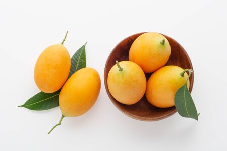 Marian plum or plum mango in wooden bowl on white background, top viewの写真素材