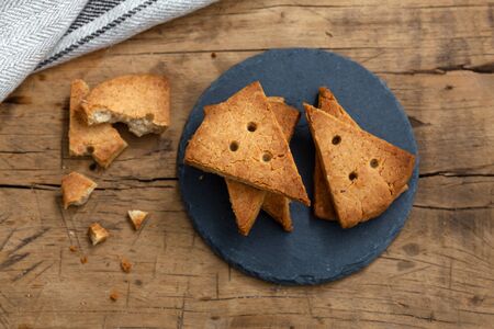 Shortbread biscuit on black stone plate on rustic wood table, flat layの写真素材