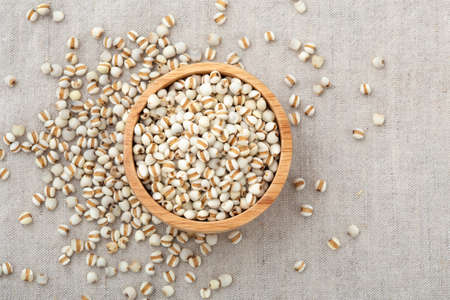 Pearl barley in wooden bowl on table with copy space, top viewの写真素材