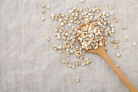 Pearl barley in wooden spoon on table with copy space, top viewの写真素材